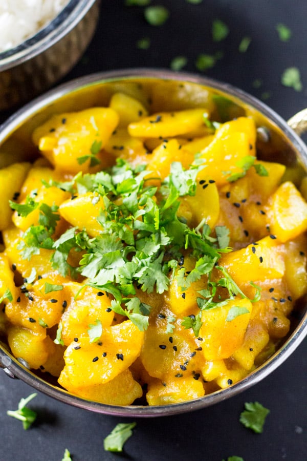 Bowl fo Indian potato curry with garnish.