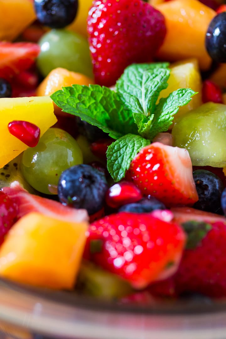 A close up shot of pineapple fruit salad topped with a garnish of mint leaves.