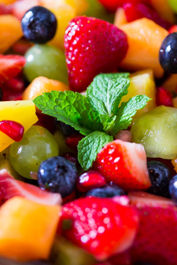 A close up shot of colorful fruits mixed together in a bowl.