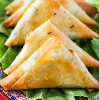 Baked Spinach & Feta Cheese Samosa on a bed of green lettuce on a beautiful blue plate