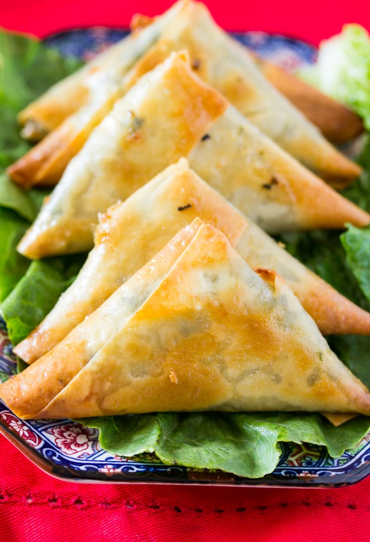 Baked Spinach & Feta Cheese Samosa on a bed of green lettuce on a beautiful blue plate