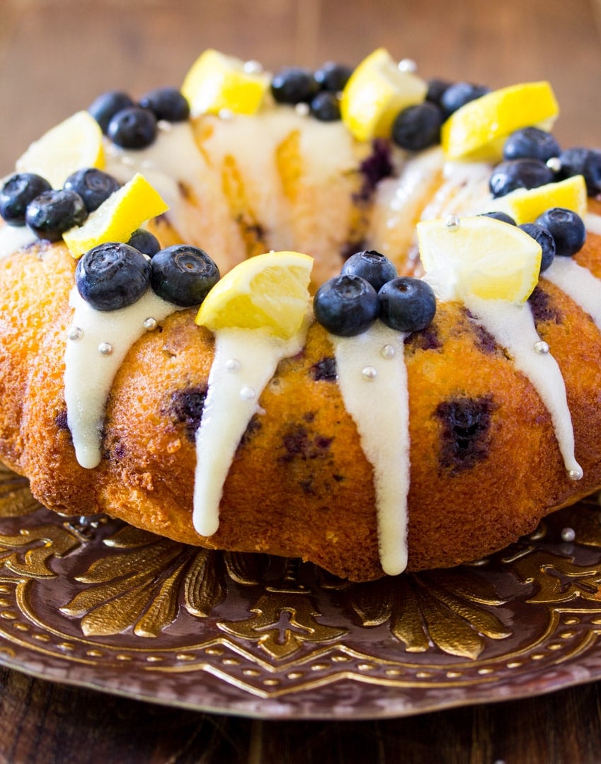 Blueberry Lemon Cake drizzled with cream cheese icing and decorated with blueberries and lemons