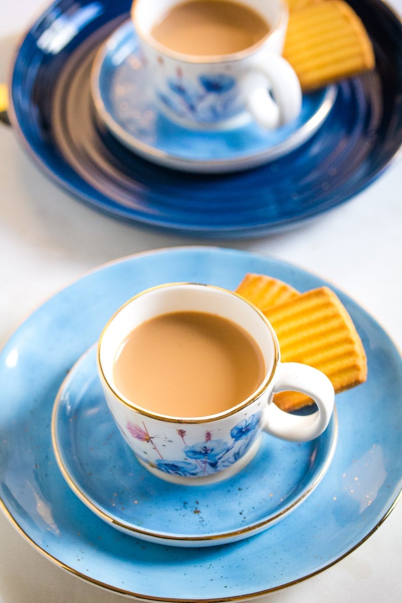 Close up of chai served with two biscuits.