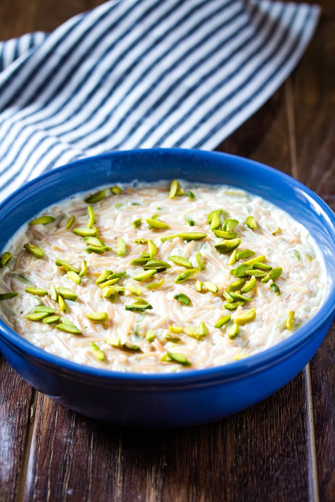 Vermicelli Kheer in a blue bowl topped with slivered pistachios.