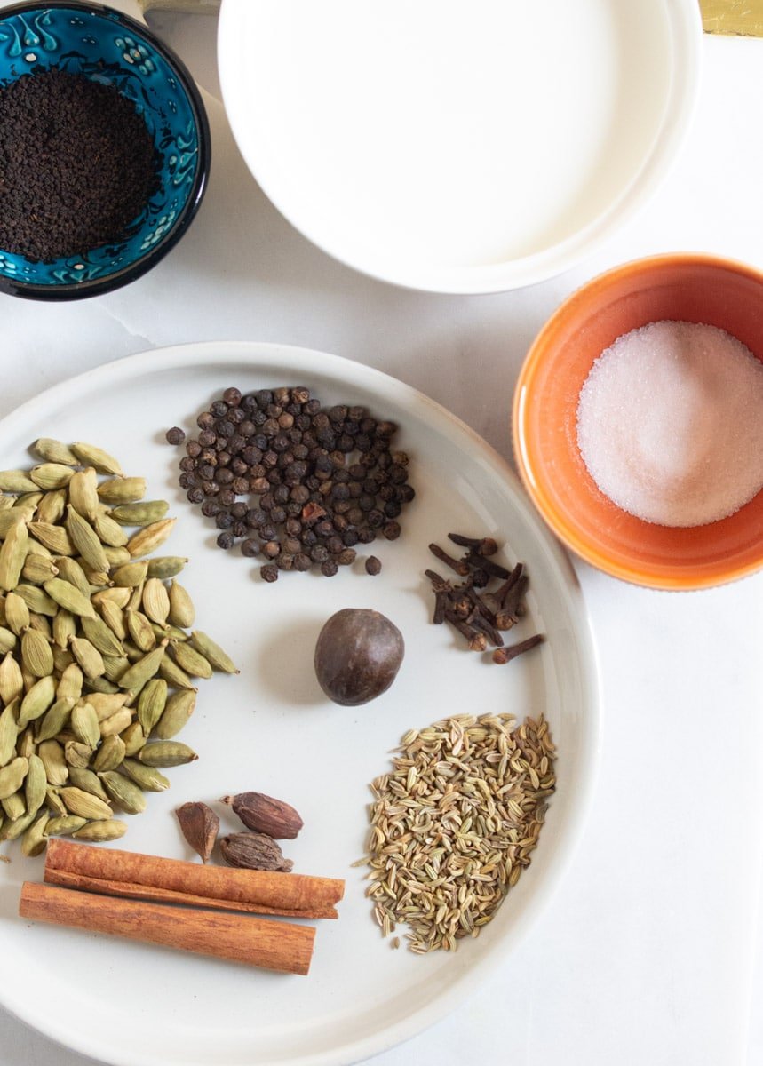 Ingredients for masala chai: spices, sugar, tea leaves, and milk.