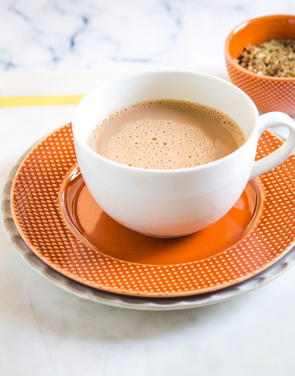 Chai Masala in a white cup on an orange saucer.
