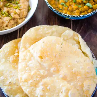 Poori on the blue plate served with chana masala and suji ka（青い皿に乗せたプーリにチャナマサラとスージカを添えて halwa