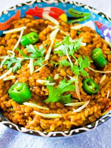 Daal Mash Served in a blue bowl topped with green chillies and coriander
