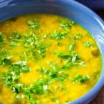 Moong Dal Tadka served in a blue bowl, garnished with chopped coriander. Served with white rice.