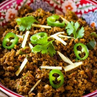 Pakistania keema served in a red bowl with rice and salad