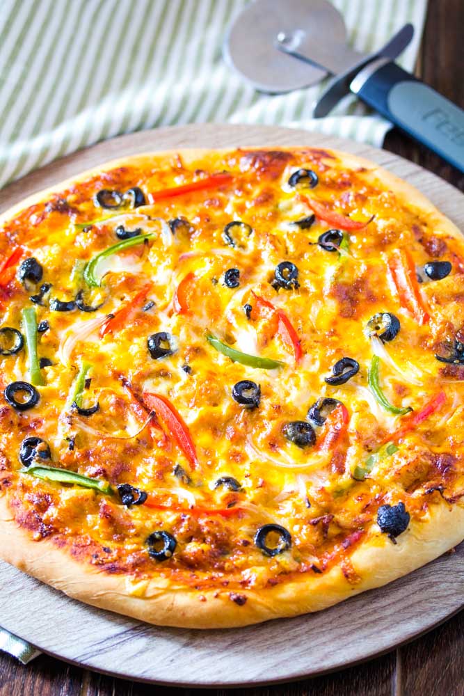 Tandoori chicken pizza with peppers and olives.