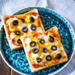 pizza toast with olives on a blue plate
