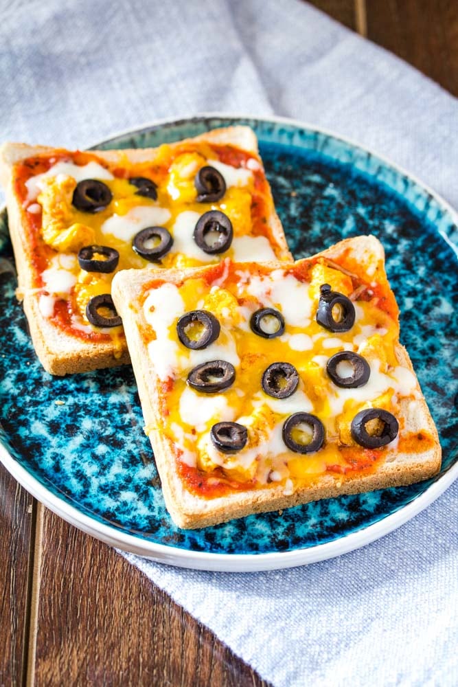 bread pizza with olives and cheese on a blue plate