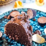 close up of triple chocolate bundt cake on a blue plate laid out on a marble background.