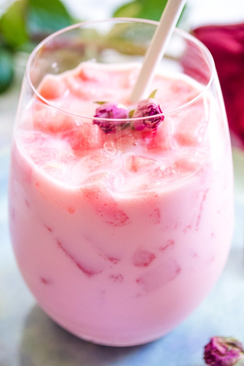 watermelon and rose syrup milkshake with a white straw.