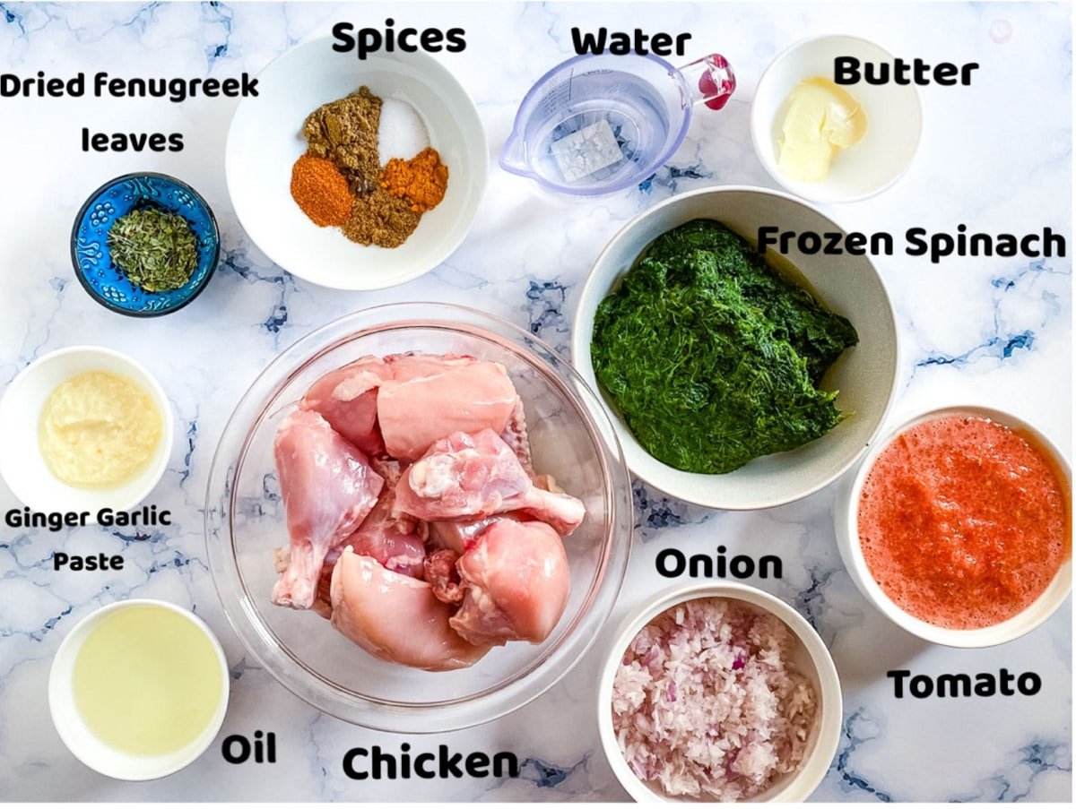 Various ingredients for palak chicken in bowls. 