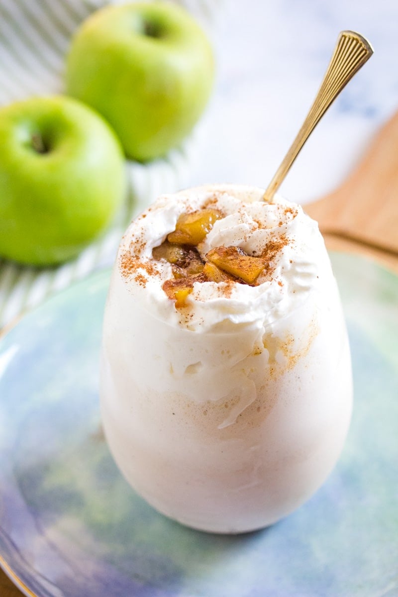 ice cream shake made with apples with a golden spoon in a round glass.