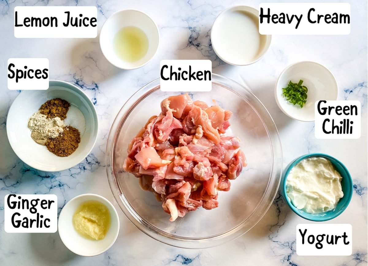 photo of ingredients needed to make murgh tikka on a white marble backdrop.