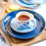 Honey Lemon Tea served in small white patterned cups placed on blue plates.