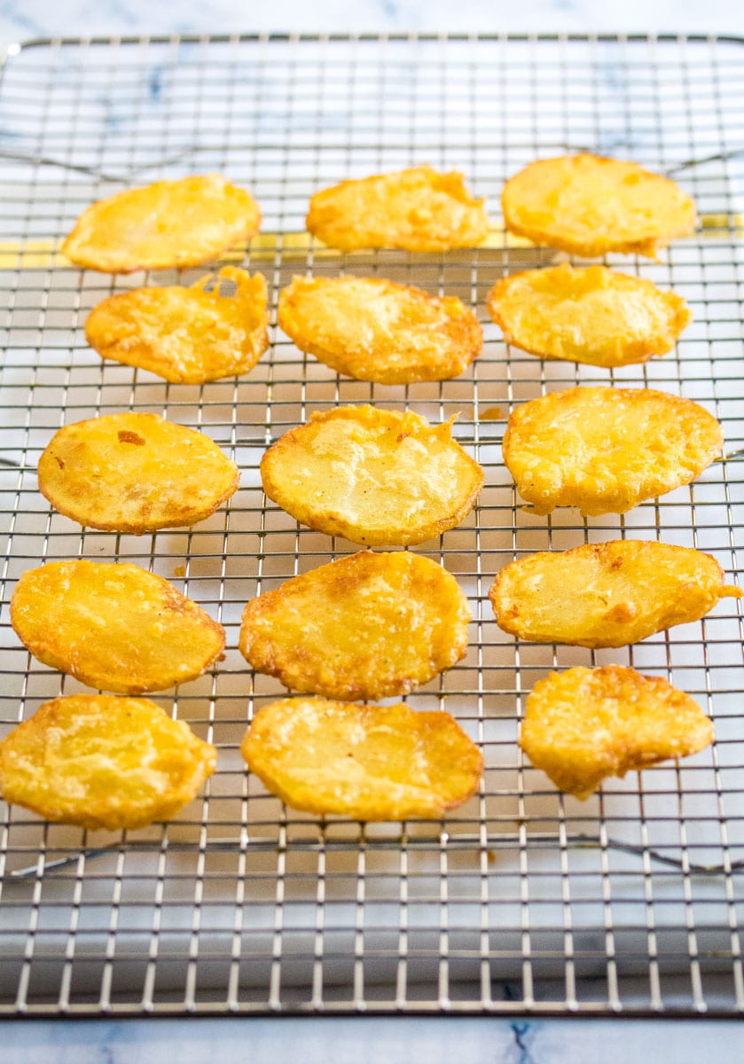 Freshly fried aloo pakora laid out on cooling rack to keep them crispy.