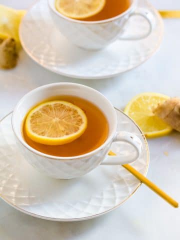 Green Tea with Ginger in a white tea cup with a slice of lemon in it.