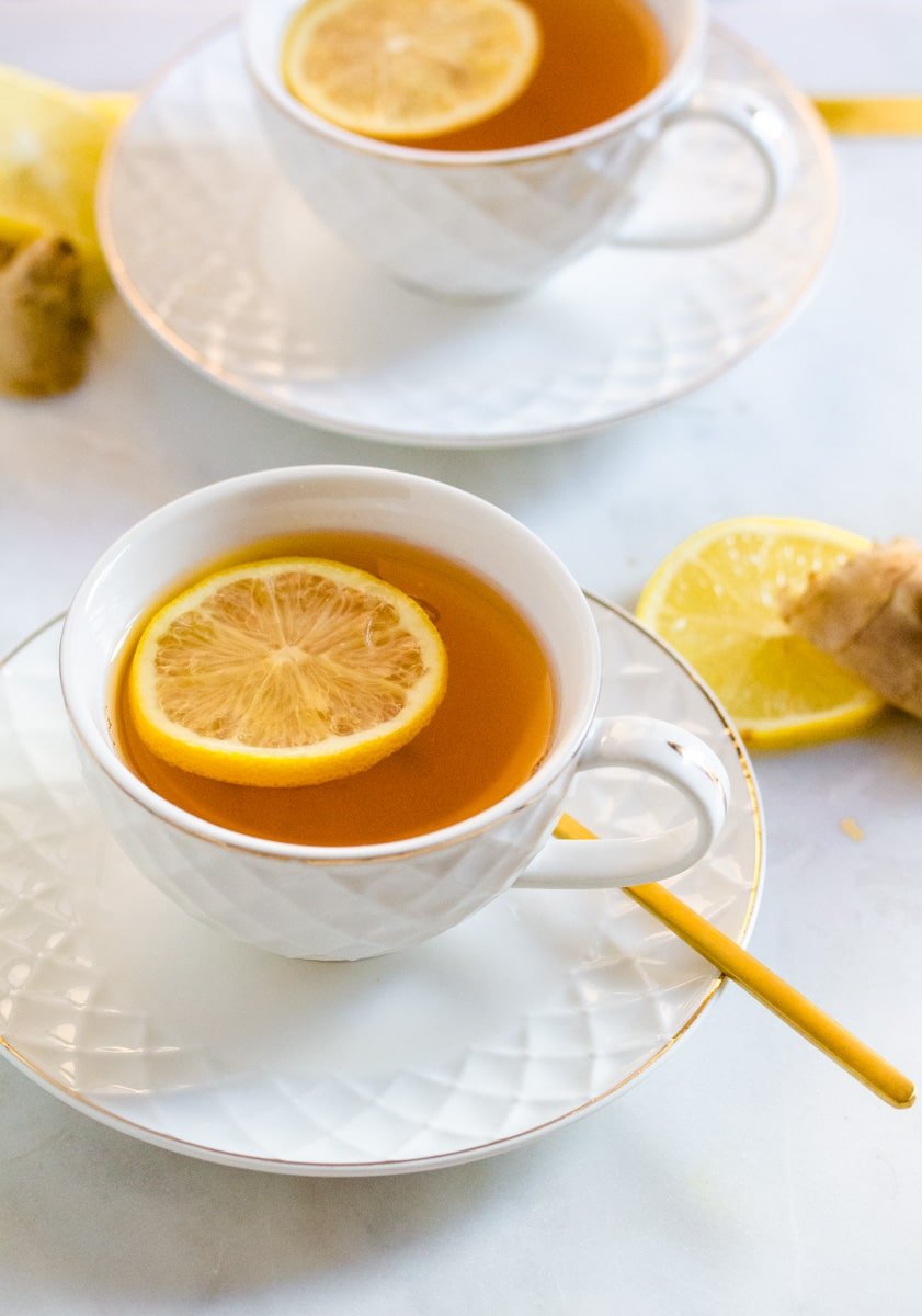 Green Tea with Ginger in a white tea cup with a slice of lemon in it.