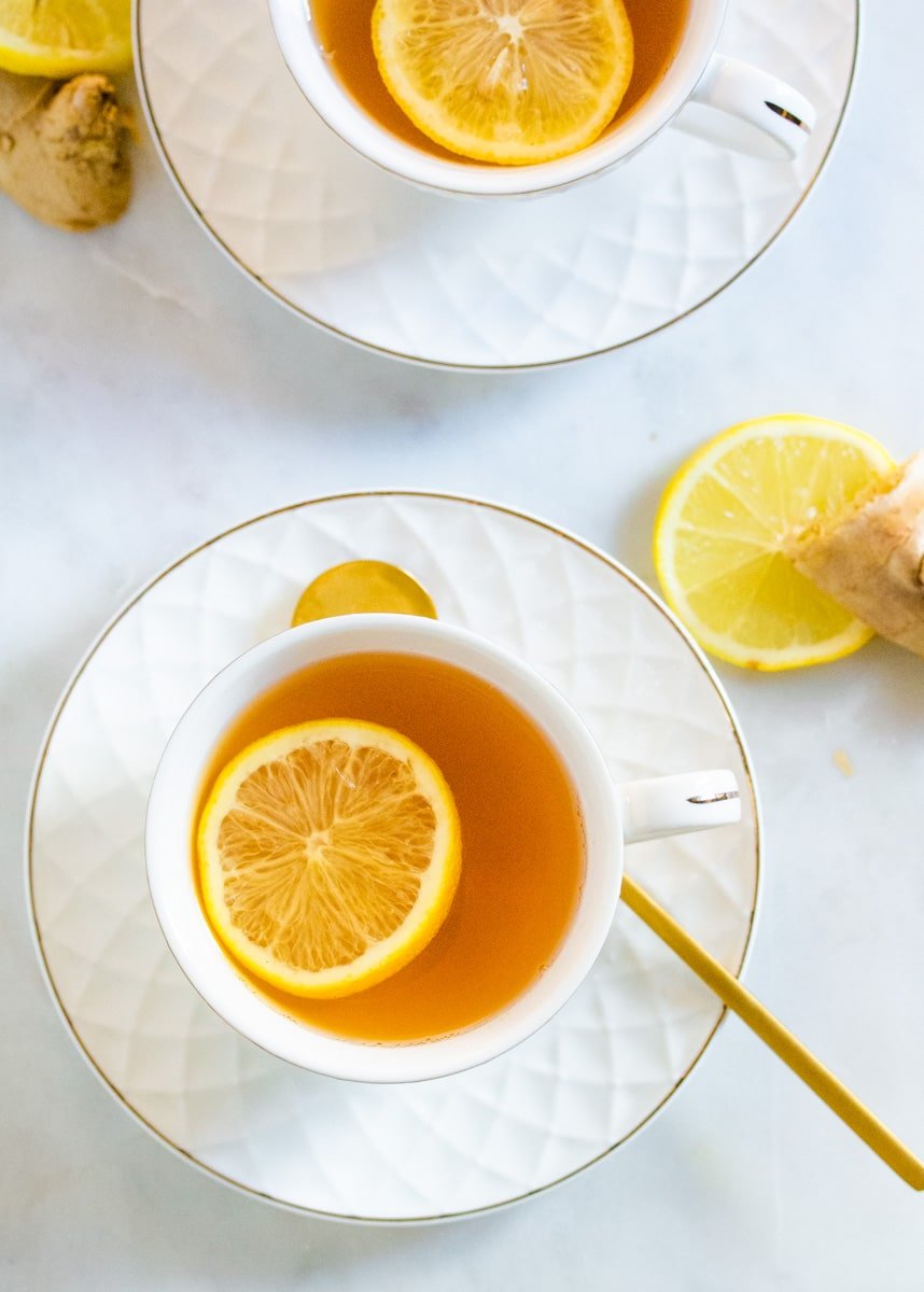 Overhead shot of ginger green tea in white cups.