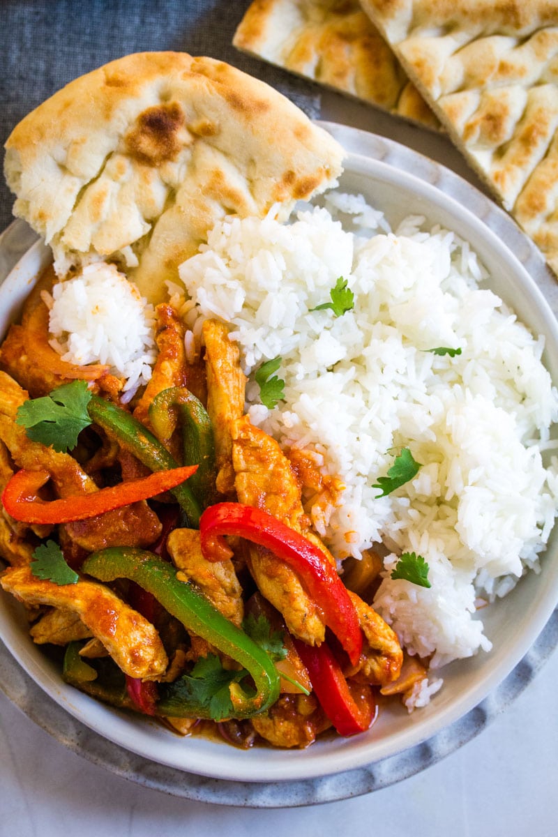 Overhead shot of jalfraizi curry served with plain boiled rice and naan. 