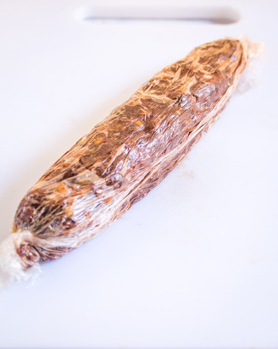 Date roll shaped into a log covered with cling film.