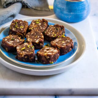 Dates Nut Roll slices served on a white marble slab.