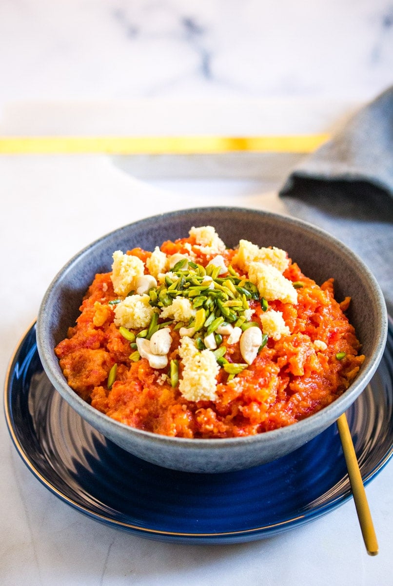 Indian Gajar ka Halwa served in a grey bowl topped with khoya.