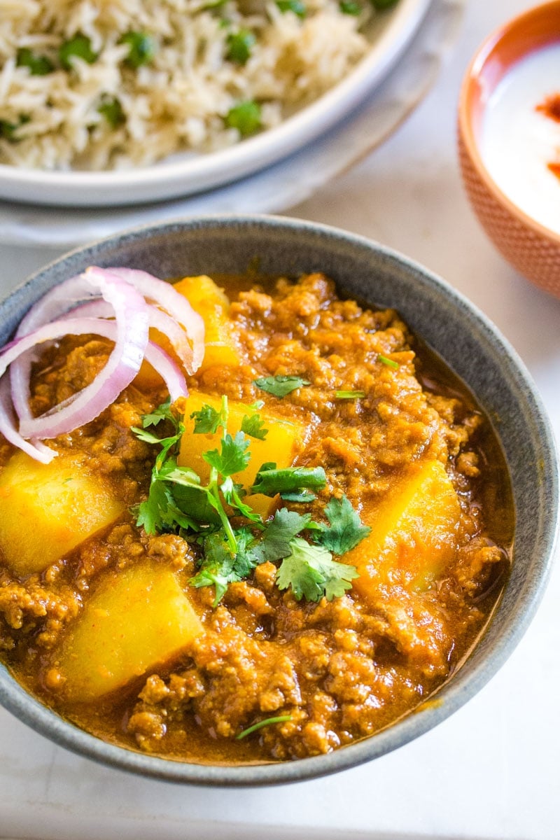 Aloo Keema served in a dark grey bowl garnished with chopped coriander.