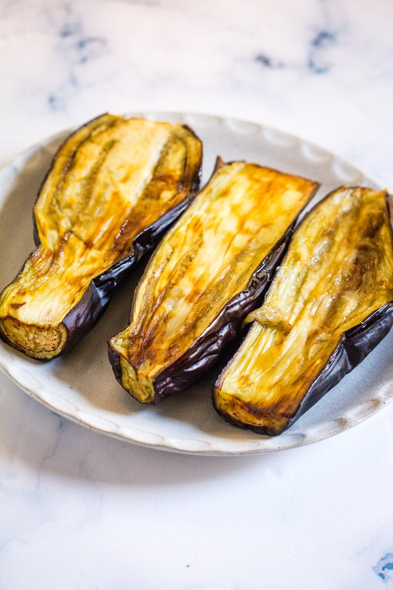 Roasted eggplant served on a white plate. 