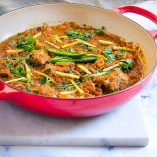 Mutton Karahi served in a red dutch oven skillet.