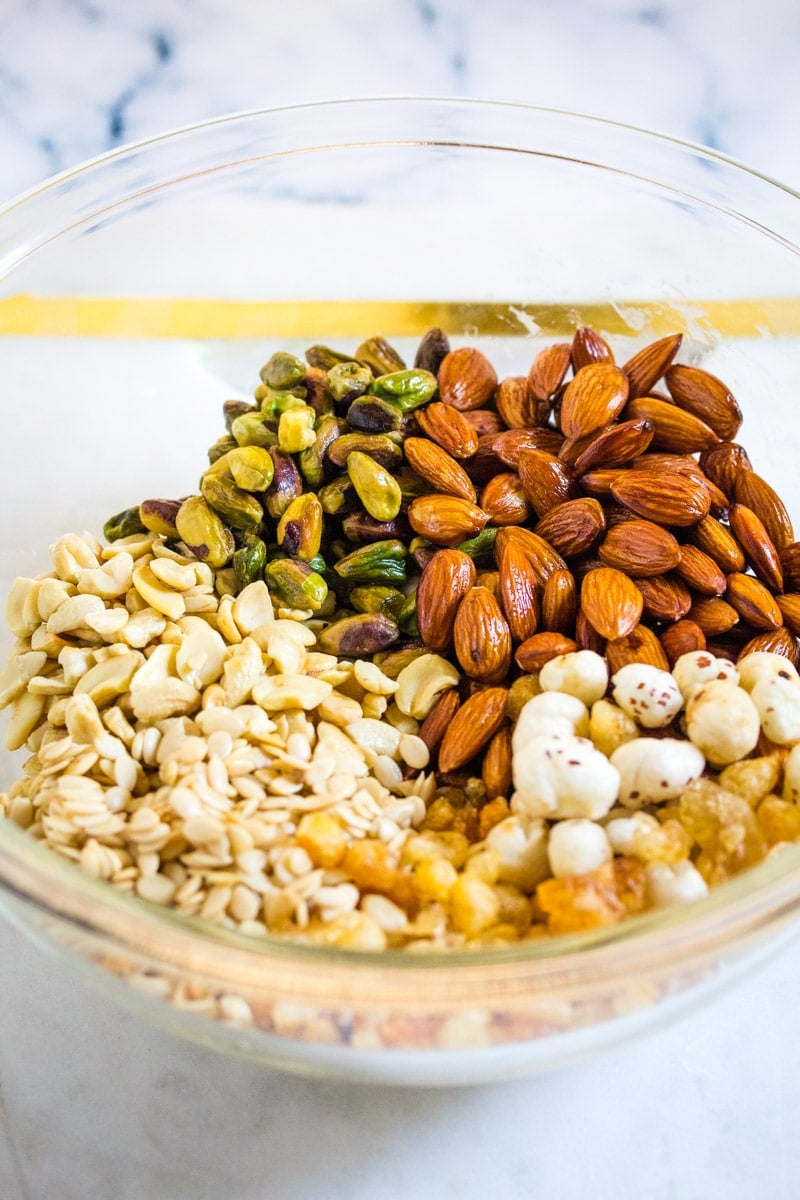 A bowl of assorted roasted nuts in ghee such as cashews, almonds, and pistachios.