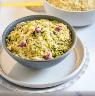 Two bowls of panjeeri placed on a white marble slab.