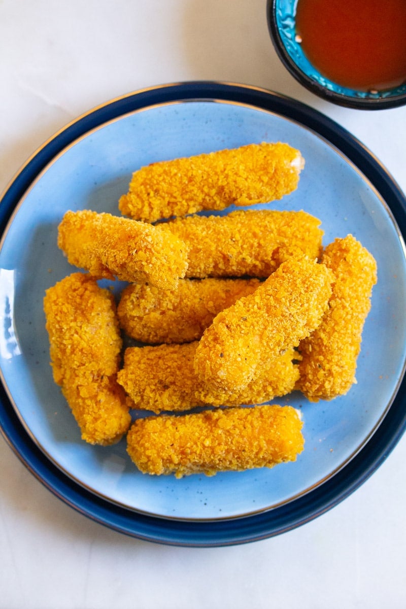 Fried cheese sticks on a blue plate.