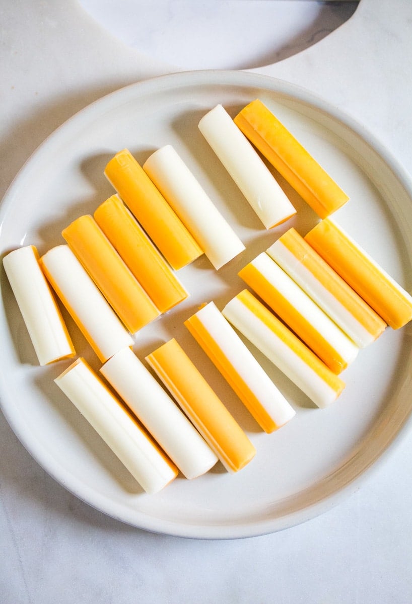 Cheese sticks cut in half on a plate.