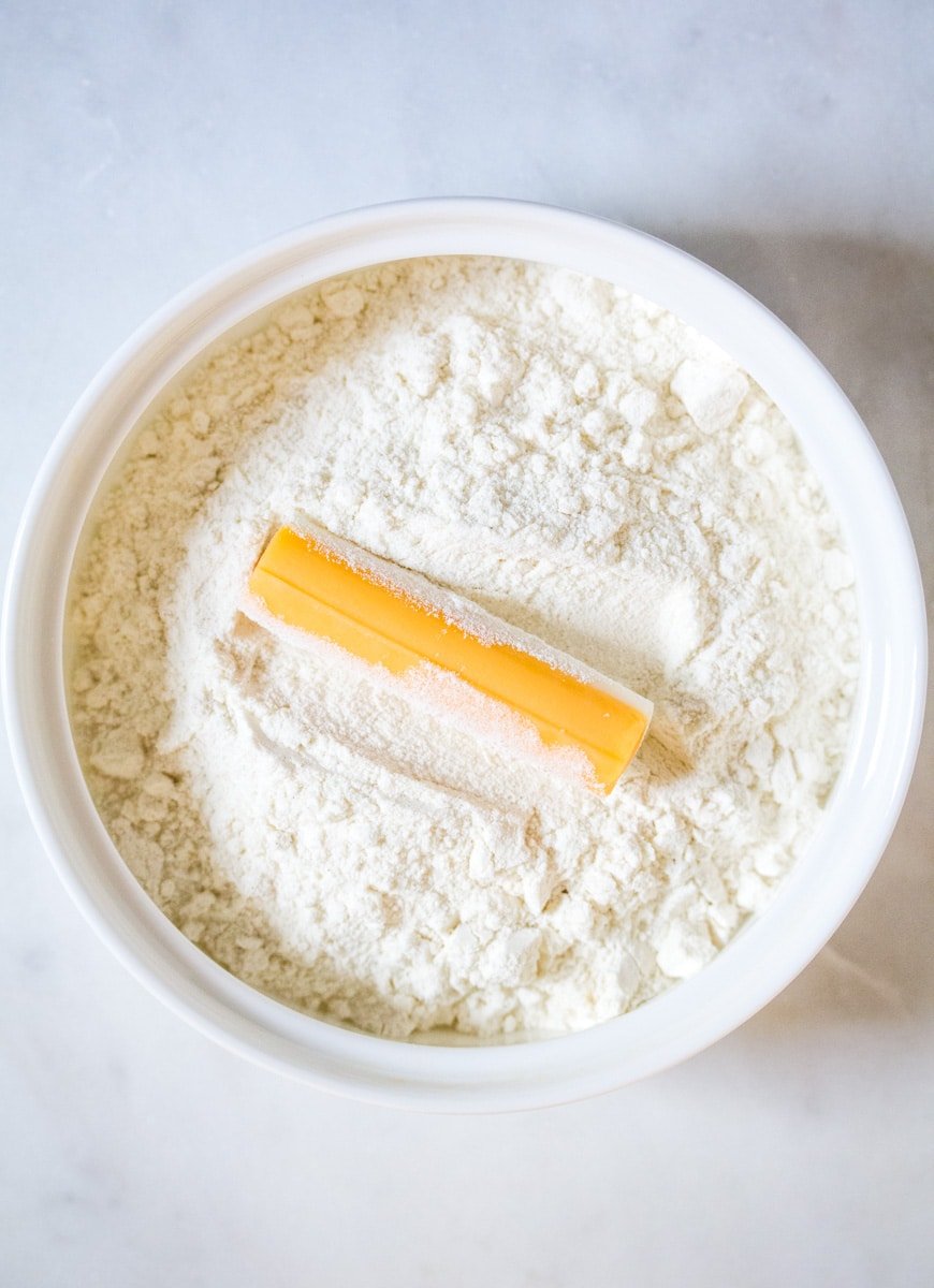 Cheese stick in a bowl of flour.