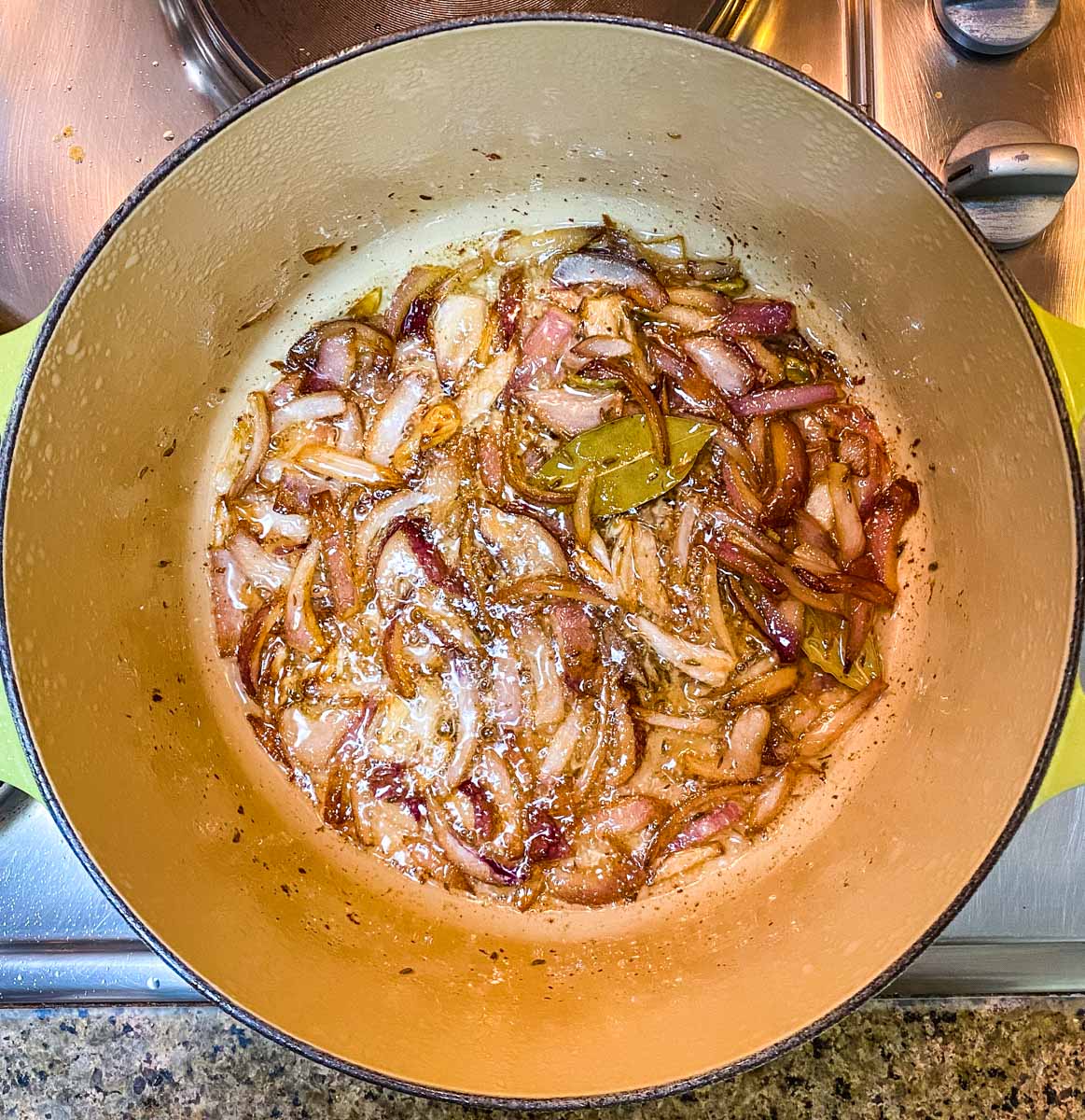 Caramelized onions with whole spices in a dutch oven pot.