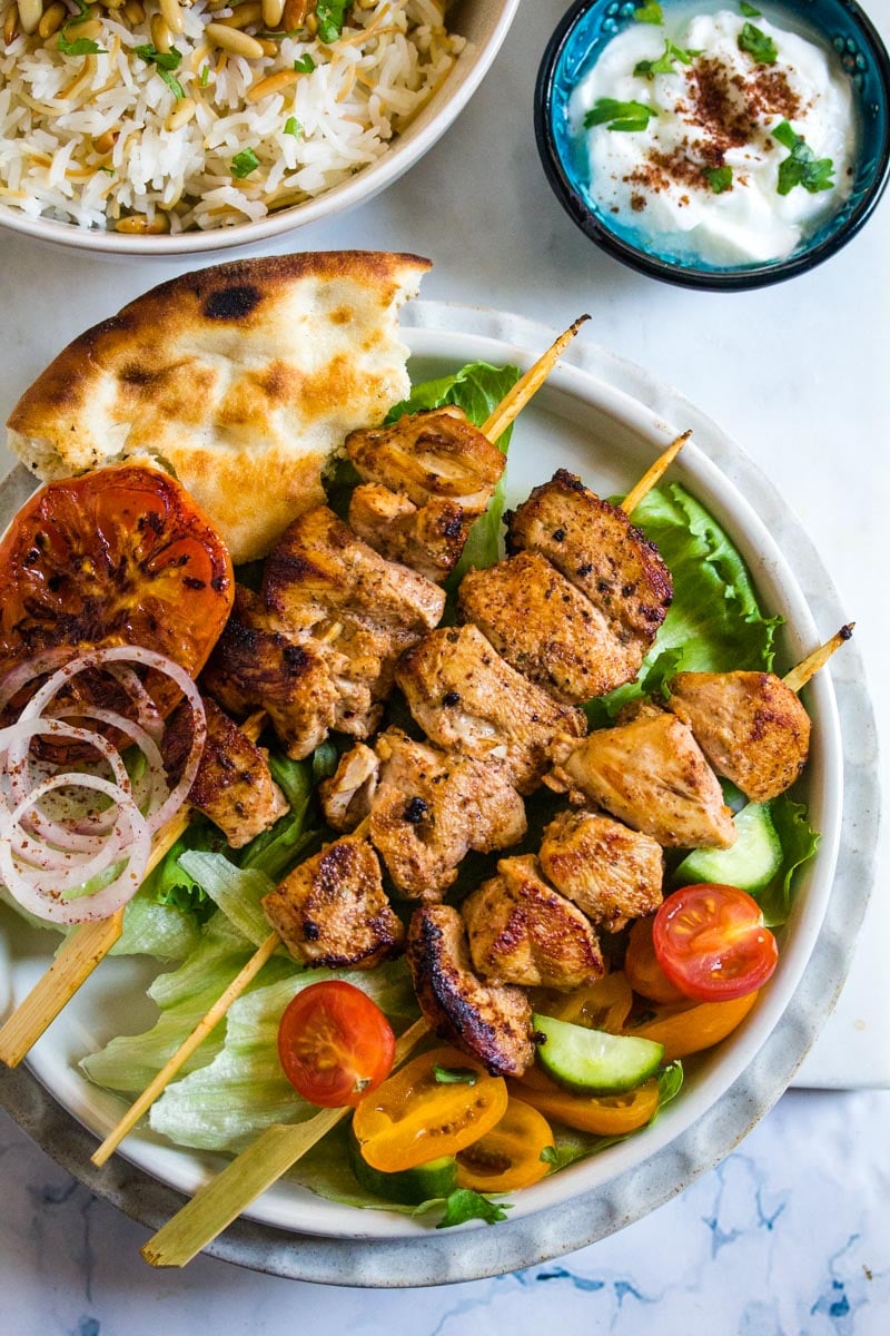 An overhead shot of a Lebanese meal with grilled chicken, vermicelli rice and yogurt.