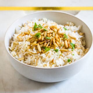 Lebanese Vermicelli Rice served in a white bowl with toasted pine nuts.