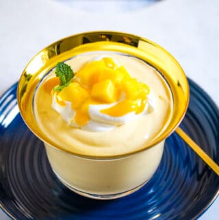 Mango Mousse served in a gold rimmed glass bowl with a gold spoon.