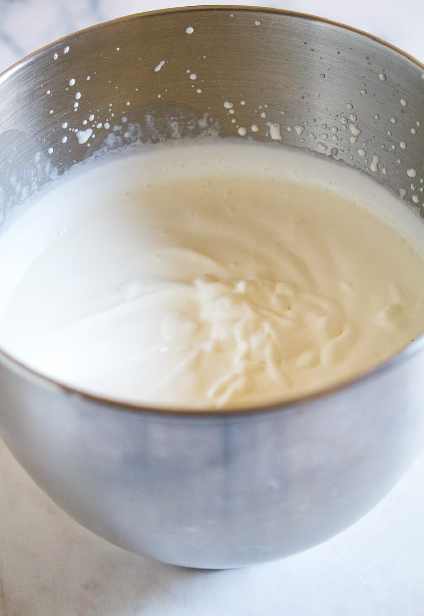 Heavy cream whipped to soft peaks in a mixing bowl.