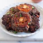 Peshawari chapli kabab served on a light grey plate.