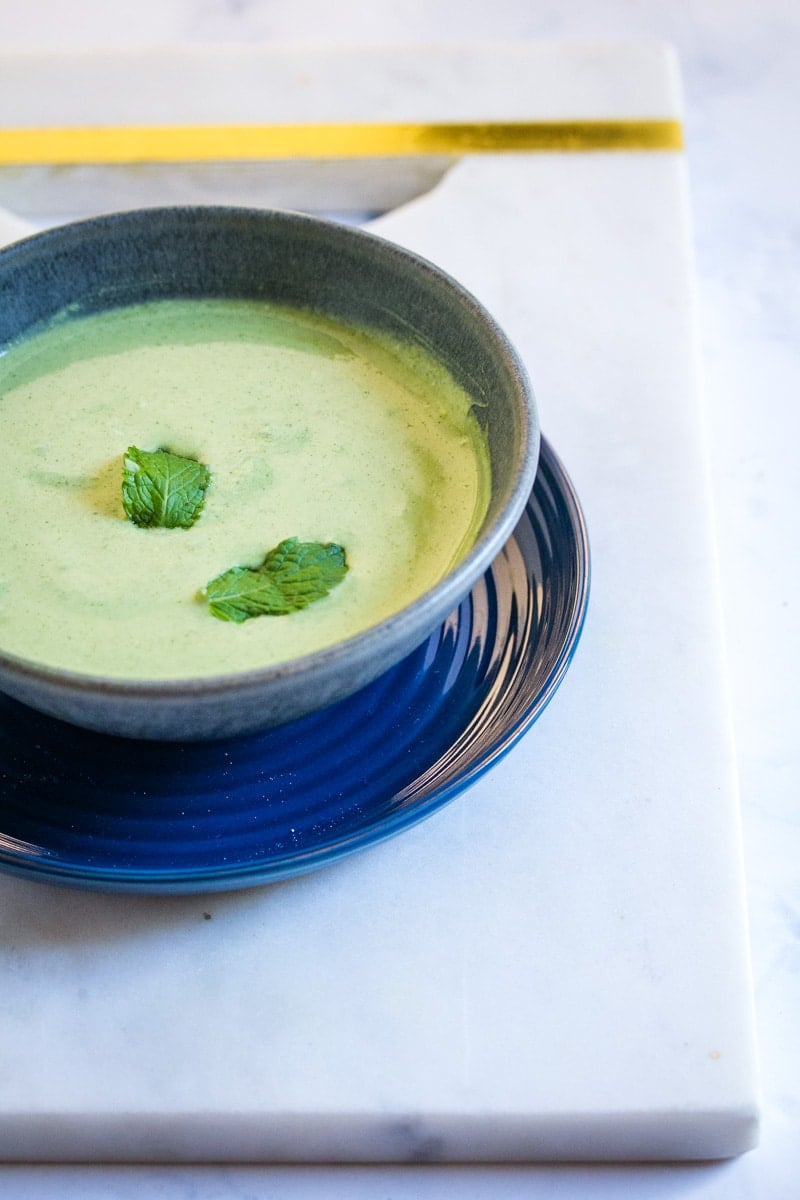 Pudina raita served in a bowl, topped with two mint leaves.