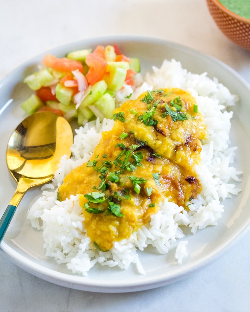 Split red lentils served with jasmine rice, kachumber salad, and a mint raita.