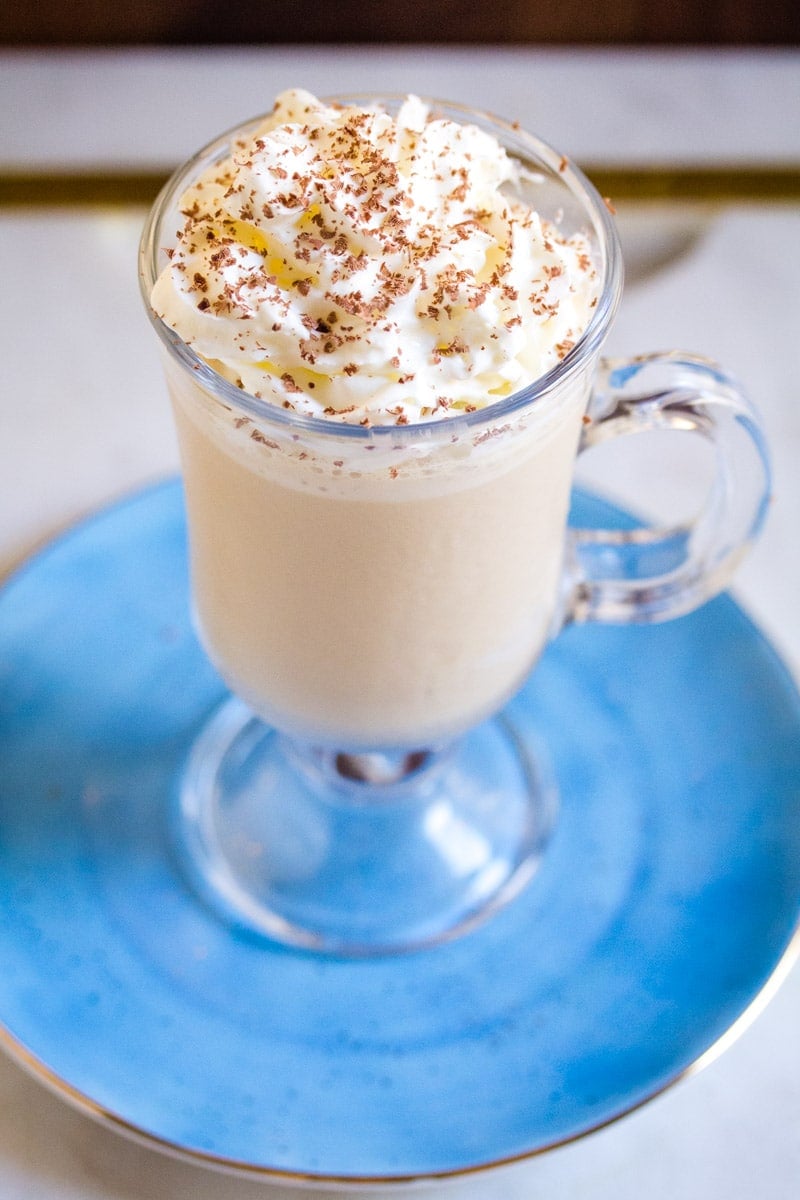 Overhead shot of milkshake made with ice cream and coffee, topped with whipping cream. 