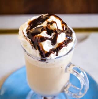 Milkshake made with cold brew coffee and vanilla ice cream, served in a glass on top of a light blue plate.